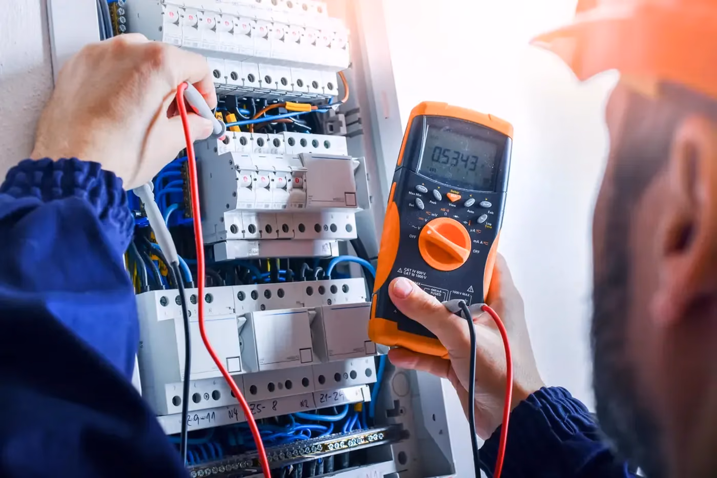 Elektriker mäter i en öppen elcentral