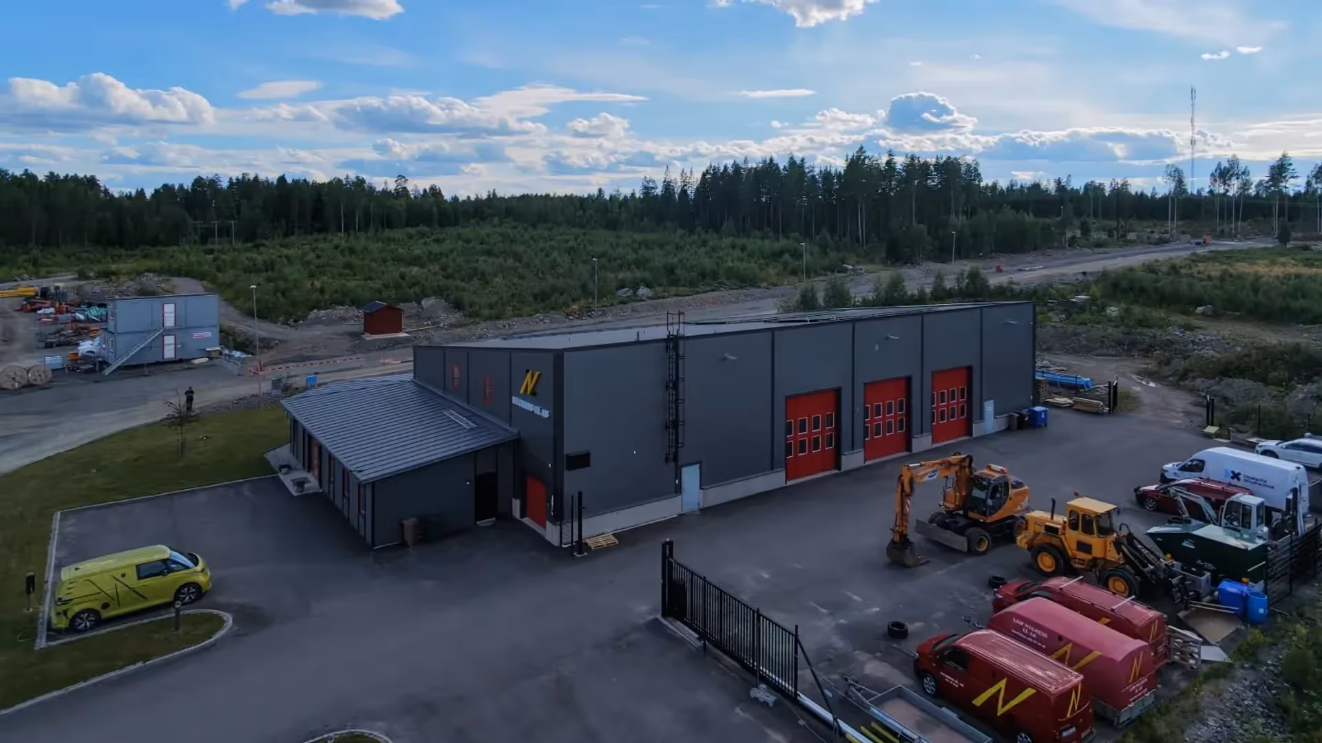 Verkstadssidan av Nygrens El med portar, servicebilar och maskiner